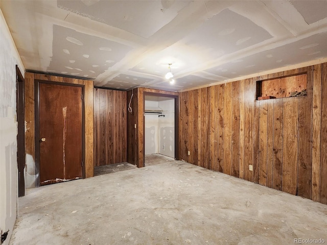 finished basement featuring wood walls