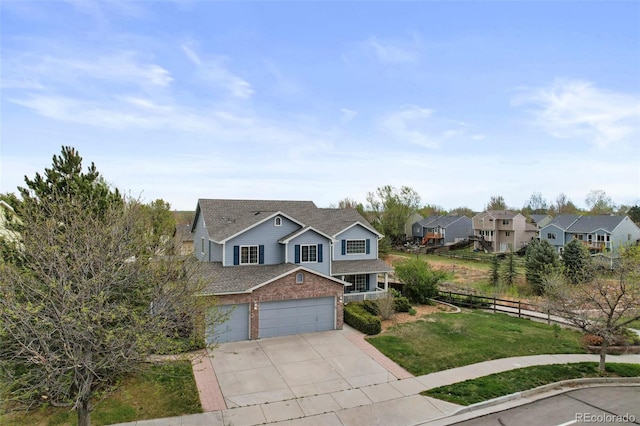 traditional-style house featuring driveway, a residential view, brick siding, fence, and a front lawn