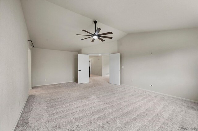 spare room featuring baseboards, a ceiling fan, light colored carpet, and lofted ceiling