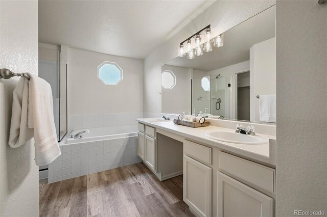 bathroom with a garden tub, a sink, double vanity, and a shower stall