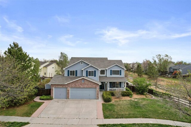 traditional home with driveway, a garage, brick siding, fence, and a front lawn