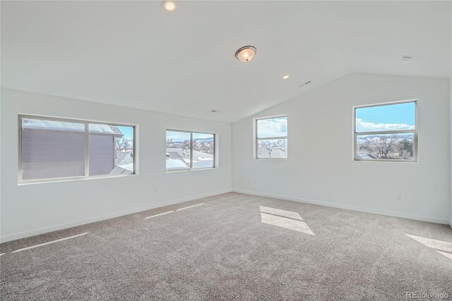 carpeted empty room featuring vaulted ceiling and a healthy amount of sunlight