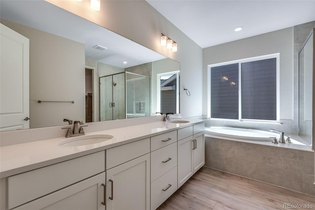 bathroom with independent shower and bath, vanity, and wood-type flooring