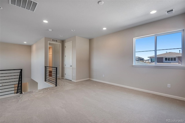 spare room featuring light colored carpet