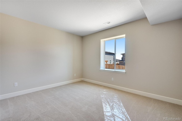 unfurnished room featuring light carpet