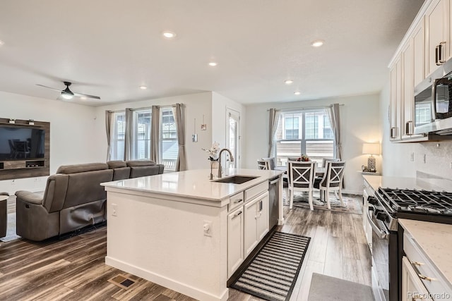 kitchen featuring an island with sink, stainless steel appliances, sink, and white cabinets