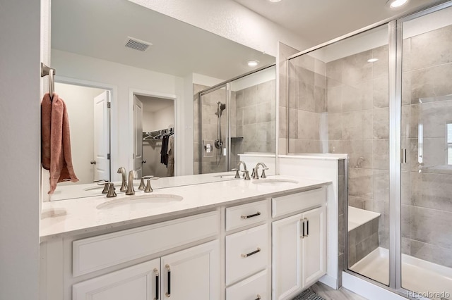 bathroom with vanity and a shower with door