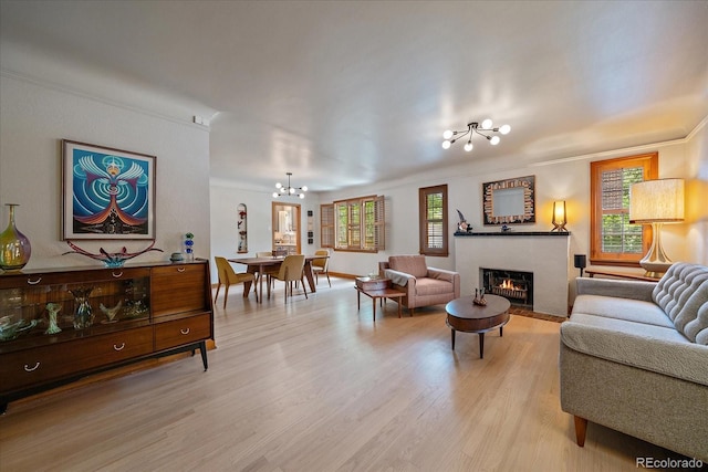1040 N Kearney St, Denver, CO 80220 - living area featuring a chandelier, a fireplace with flush hearth, light wood-style floors, crown molding, and healthy amount of natural light