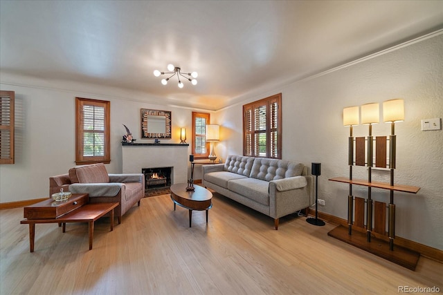 1040 N Kearney St, Denver, CO 80220 - living area featuring healthy amount of natural light, wood finished floors, a fireplace with flush hearth, a chandelier, and ornamental molding