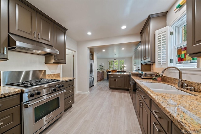 1040 N Kearney St, Denver, CO 80220 - kitchen featuring high end appliances, under cabinet range hood, light stone countertops, recessed lighting, and dark brown cabinets