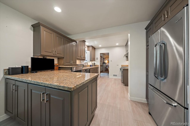 1040 N Kearney St, Denver, CO 80220 - kitchen featuring high end refrigerator, a peninsula, recessed lighting, light stone countertops, and gray cabinetry