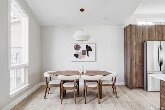 dining area with light hardwood / wood-style floors and a wealth of natural light