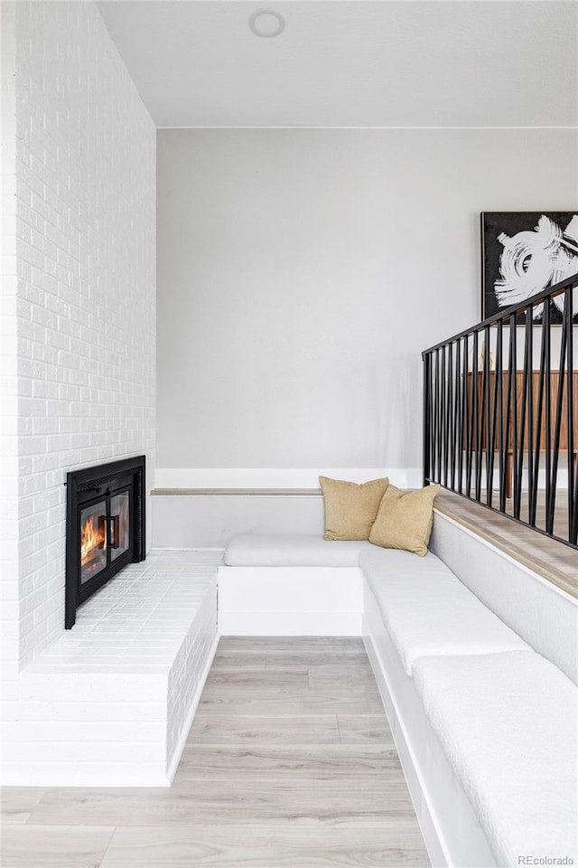 living room with hardwood / wood-style flooring and a brick fireplace