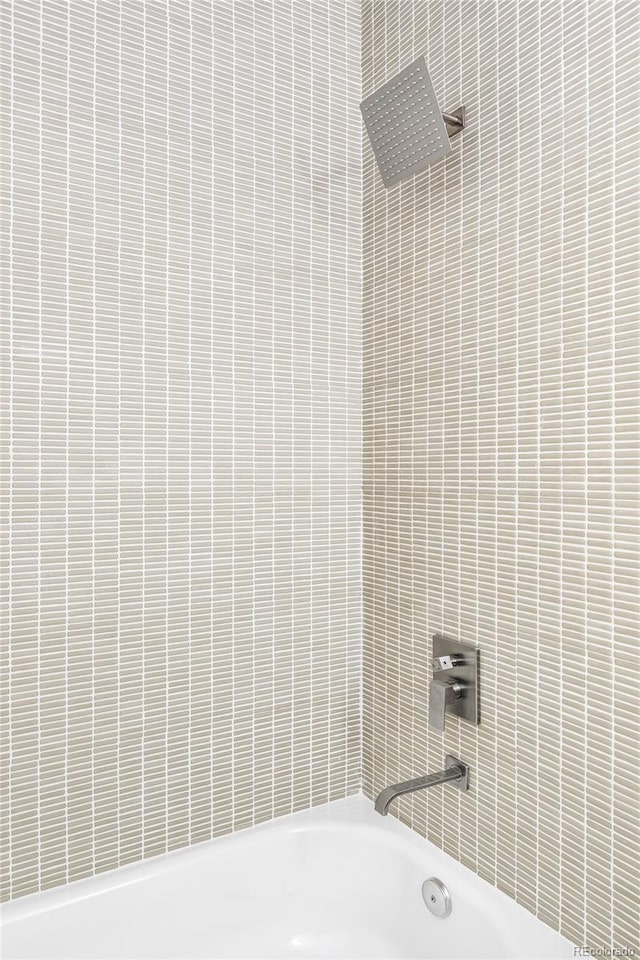 bathroom with tiled shower / bath combo