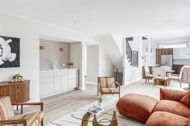 living room featuring light wood-type flooring and sink