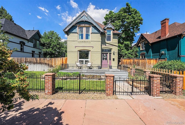 2831 N Humboldt St, Denver, CO 80205 - victorian home with a fenced front yard, a gate, and brick siding