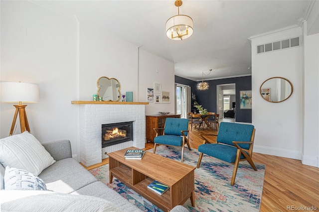 2831 N Humboldt St, Denver, CO 80205 - living area with a chandelier, a brick fireplace, wood finished floors, and crown molding