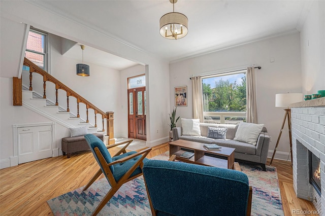 2831 N Humboldt St, Denver, CO 80205 - living area featuring stairway, a chandelier, crown molding, a fireplace, and light wood-style floors