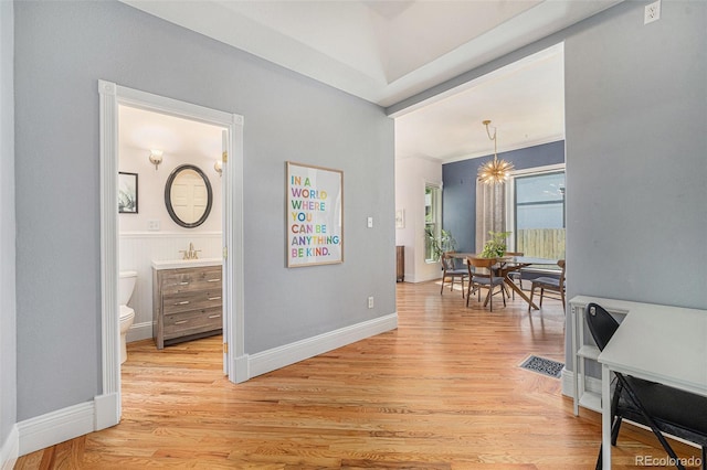 2831 N Humboldt St, Denver, CO 80205 - hallway with light wood-type flooring and a chandelier