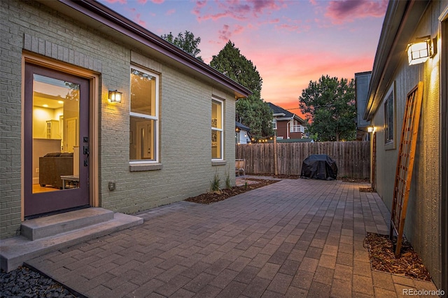 2831 N Humboldt St, Denver, CO 80205 - patio terrace at dusk featuring a patio, a fenced backyard, and area for grilling