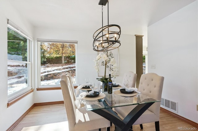 dining area featuring an inviting chandelier and light hardwood / wood-style flooring