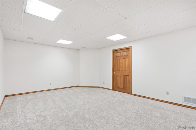 spare room with a paneled ceiling and carpet