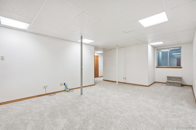 basement with carpet flooring and a drop ceiling