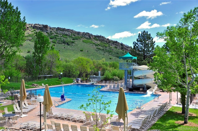 view of pool with a mountain view, a patio, and a water slide