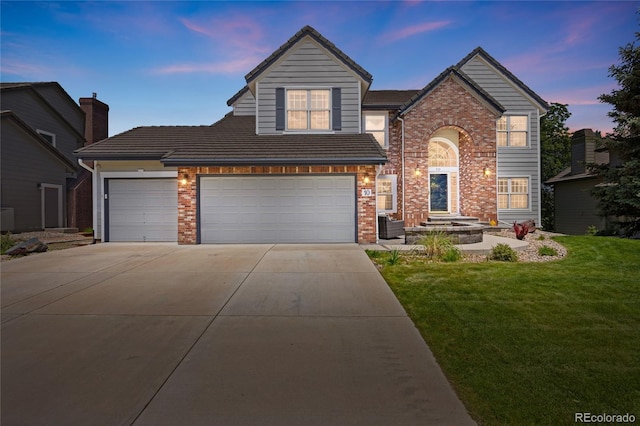 10 Sand Cherry, Littleton, CO 80127 - traditional-style home with driveway, a front lawn, brick siding, and an attached garage