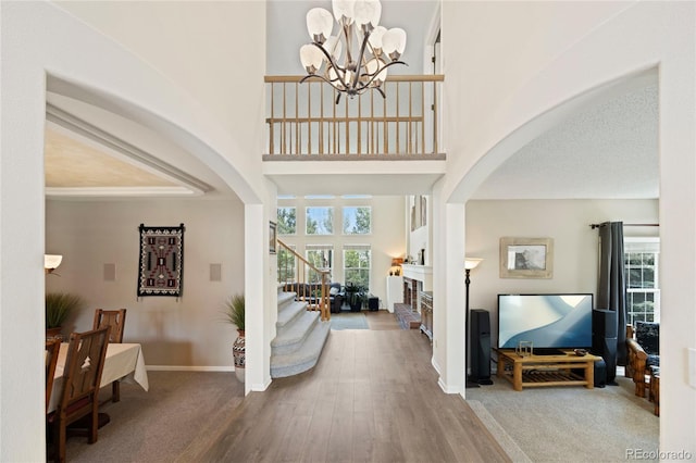 10 Sand Cherry, Littleton, CO 80127 - foyer entrance featuring arched walkways, a chandelier, a high ceiling, a fireplace, and stairs