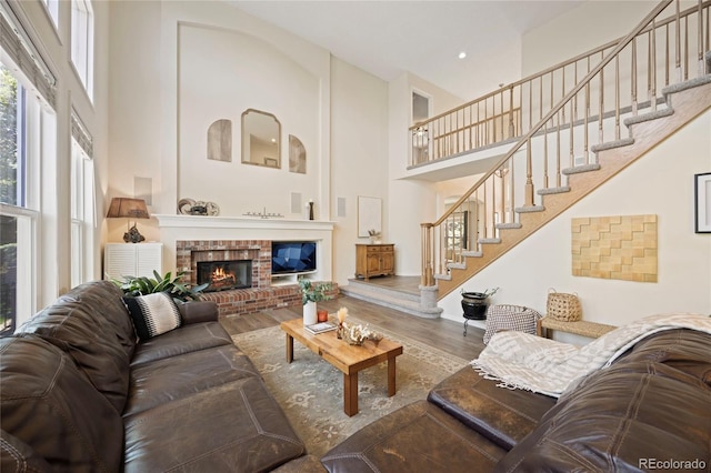 10 Sand Cherry, Littleton, CO 80127 - living area featuring a towering ceiling, wood finished floors, a brick fireplace, stairway, and recessed lighting