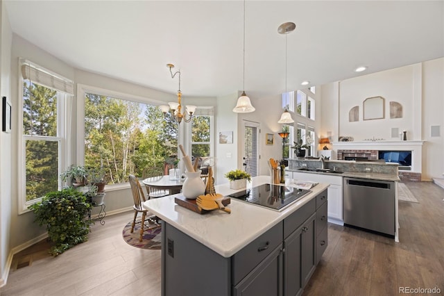 10 Sand Cherry, Littleton, CO 80127 - kitchen featuring dishwasher, black electric cooktop, a chandelier, dark wood-type flooring, and a kitchen island