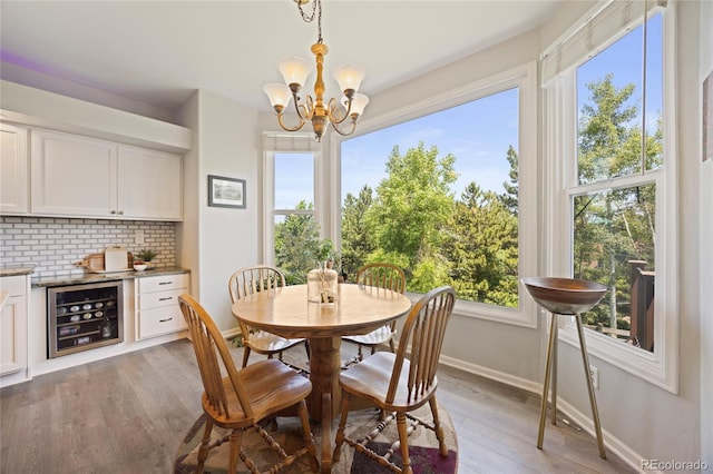 10 Sand Cherry, Littleton, CO 80127 - dining space with wine cooler, baseboards, a chandelier, and light wood finished floors