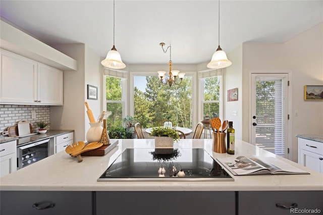 10 Sand Cherry, Littleton, CO 80127 - kitchen with black electric cooktop, wine cooler, a chandelier, and white cabinets