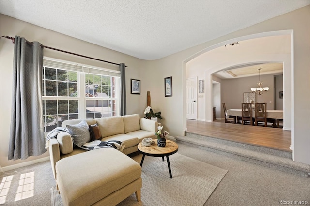 10 Sand Cherry, Littleton, CO 80127 - living area with arched walkways, carpet floors, a chandelier, baseboards, and a textured ceiling