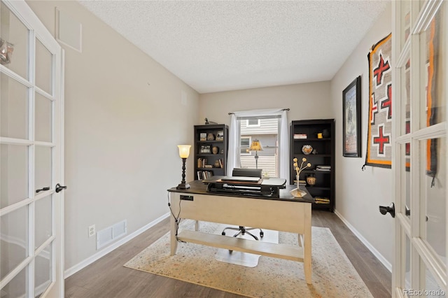 10 Sand Cherry, Littleton, CO 80127 - office featuring wood finished floors, french doors, a textured ceiling, and baseboards