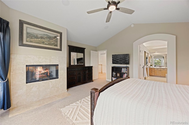 10 Sand Cherry, Littleton, CO 80127 - bedroom with arched walkways, carpet flooring, a tiled fireplace, lofted ceiling, and connected bathroom