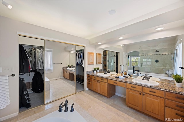 10 Sand Cherry, Littleton, CO 80127 - full bathroom with a stall shower, double vanity, a walk in closet, a garden tub, and recessed lighting