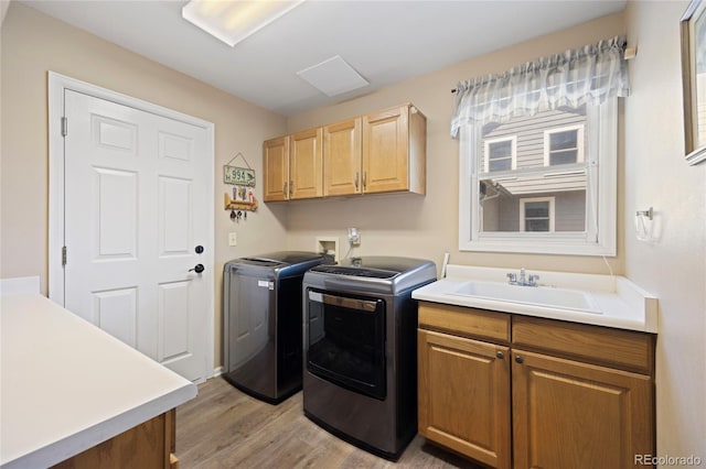 10 Sand Cherry, Littleton, CO 80127 - laundry room featuring washer and clothes dryer, light wood-type flooring, and cabinet space