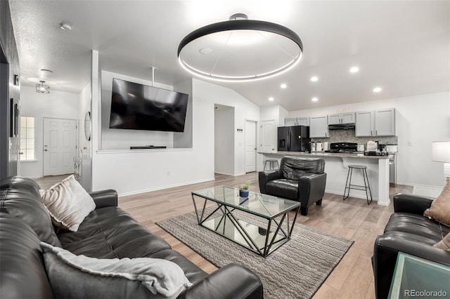 933 W Independent Ave, La Salle, CO 80645 - living area featuring recessed lighting, baseboards, vaulted ceiling, and light wood-style flooring