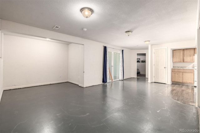 933 W Independent Ave, La Salle, CO 80645 - interior space with a textured ceiling, visible vents, baseboards, and finished concrete floors