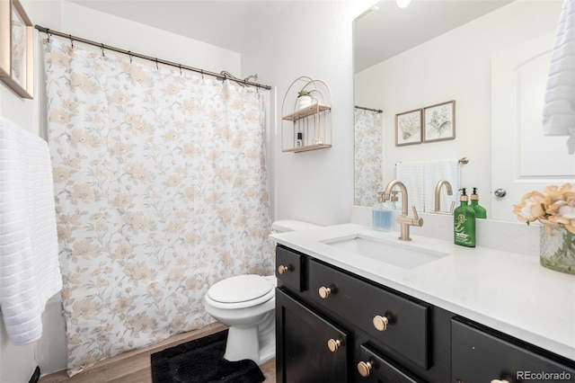 933 W Independent Ave, La Salle, CO 80645 - full bathroom featuring toilet, wood finished floors, and vanity