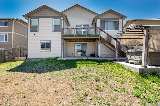 933 W Independent Ave, La Salle, CO 80645 - back of house with fence, stairs, a hot tub, a wooden deck, and a patio area