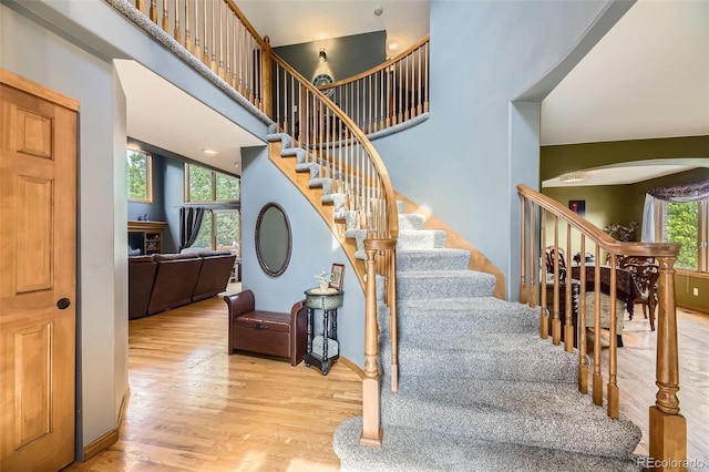 6588 S Oak Cir, Littleton, CO 80127 - staircase featuring arched walkways, wood finished floors, and a high ceiling