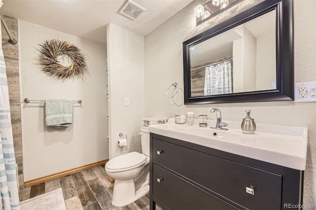 6588 S Oak Cir, Littleton, CO 80127 - full bath with vanity, wood finished floors, a shower with shower curtain, and a textured wall