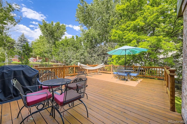 6588 S Oak Cir, Littleton, CO 80127 - wooden terrace with outdoor dining area, a grill, and view of scattered trees