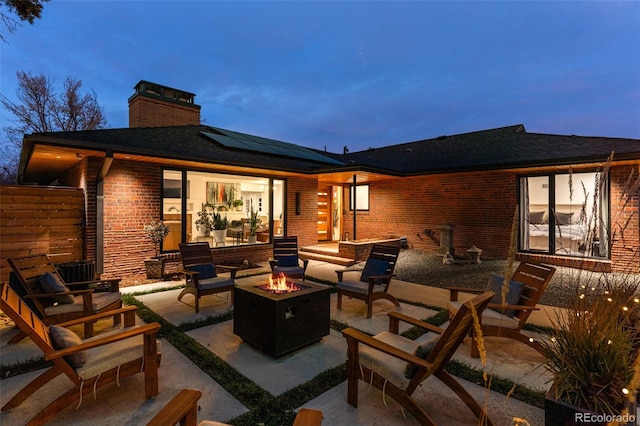 patio terrace at dusk featuring an outdoor living space with a fire pit