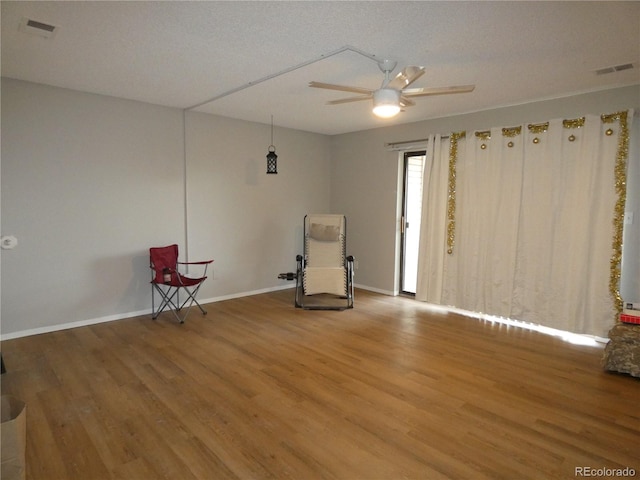 unfurnished room with visible vents, baseboards, ceiling fan, and wood finished floors