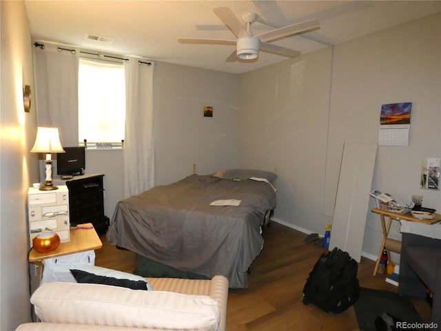 bedroom featuring visible vents, a ceiling fan, and wood finished floors