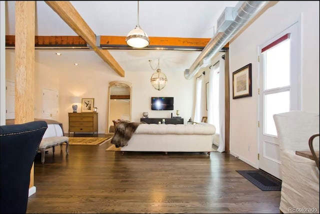 living area featuring beam ceiling, a healthy amount of sunlight, dark wood finished floors, and baseboards